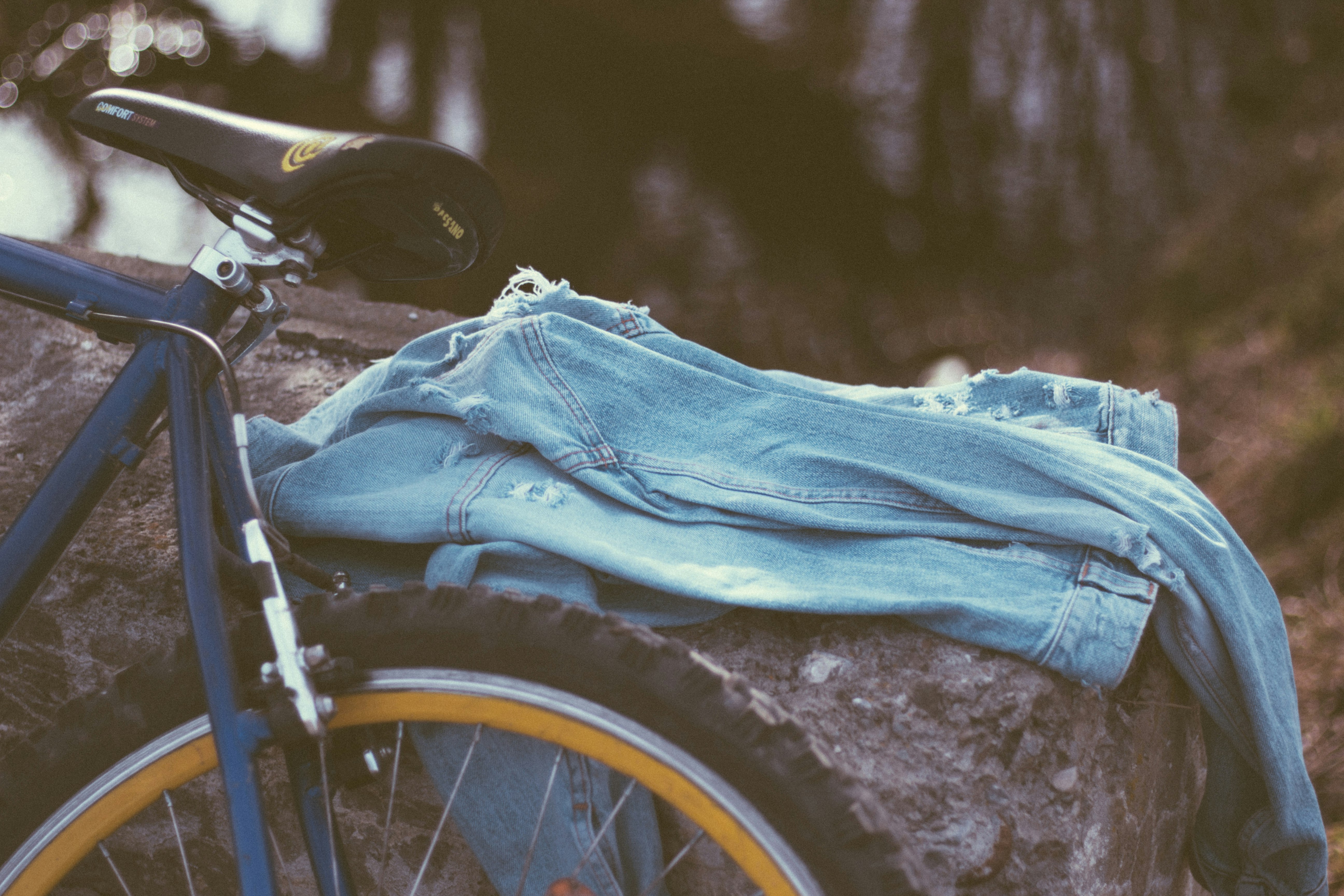 selective focus photo of blue jeans on boulder